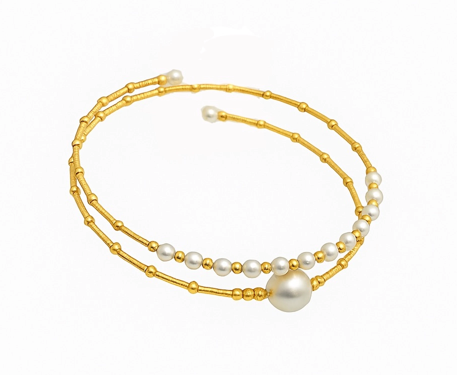 Detailed view of 18K gold bangle with lustrous Akoya pearls